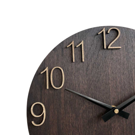 Drewniany zegar ścienny z rzeźbionymi cyframi i metalowymi wskazówkami.