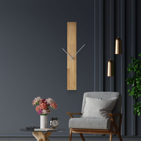 Nowoczesny zegar ścienny, przyklejony do białej ściany, z prostymi czarnymi wskazówkami.