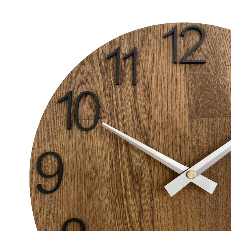 Okrągły zegar z ozdobnym wycięciem w środku i delikatnym wzorem drewna.