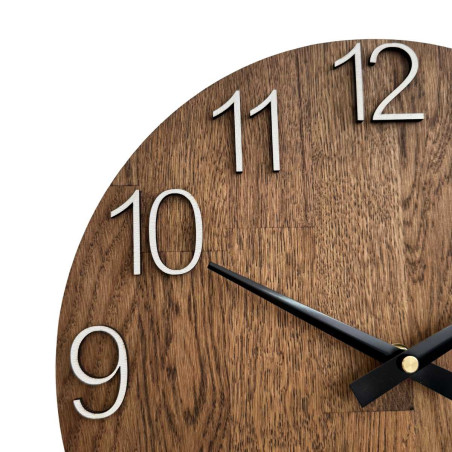 Rzeźbiony drewniany zegar z prostą tarczą i minimalistycznym wzornictwem.