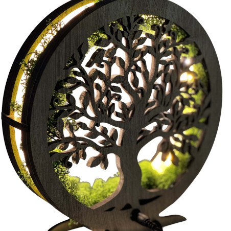 Zbliżenie na podświetlone, drewniane Drzewo Życia otoczone mchem.