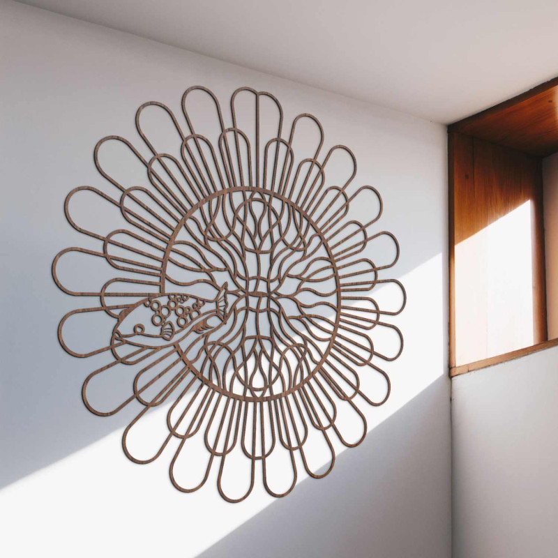 Czarna drewniana mandala z rybą na białej ścianie w nowoczesnym mieszkaniu