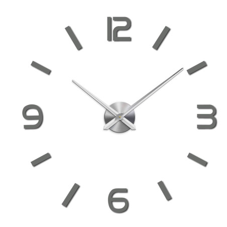 Zegar ścienny z elementami lustrzanymi w kolorze srebrnym na ścianie we wnętrzu